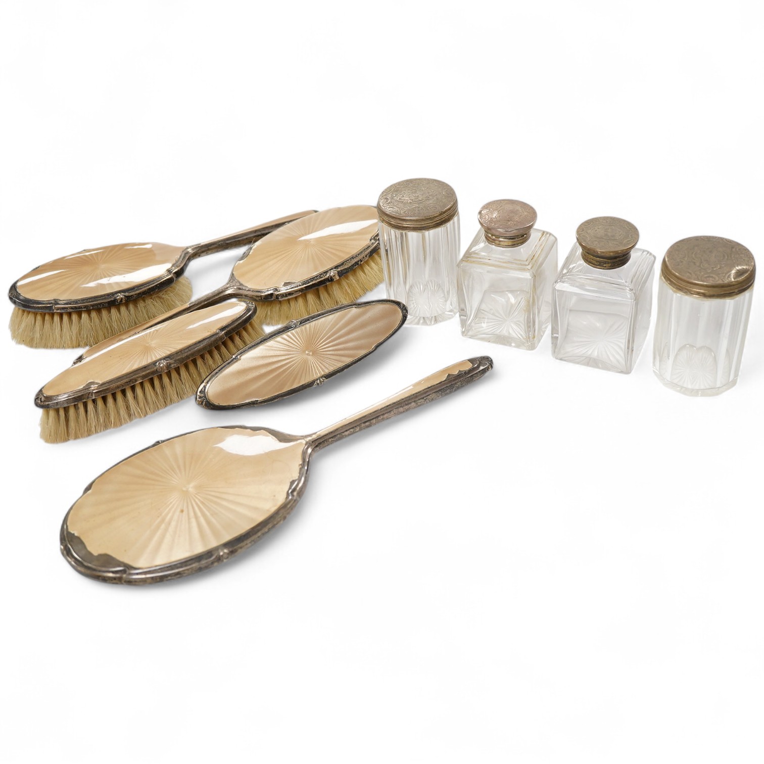 A George V silver and enamel five piece dressing table set (a.f.), together with four Victorian engraved silver topped glass toilet bottles